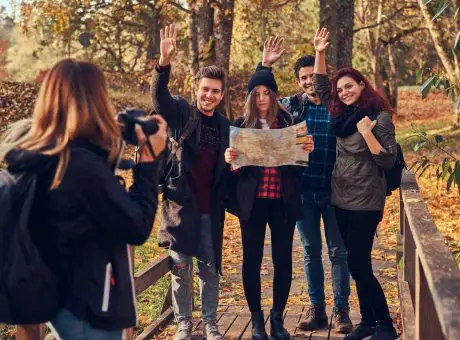 girl-taking-a-photo-of-her-friends-group-of-young-friends-hiking-through-forest-.jpg